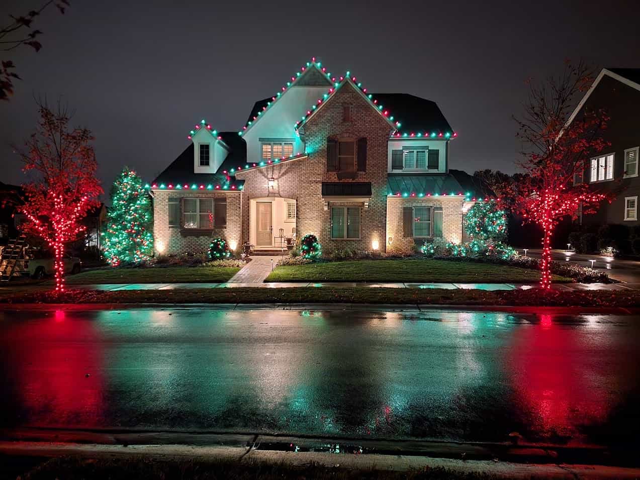 Red and green holiday lighting installed on a Charlotte-area home